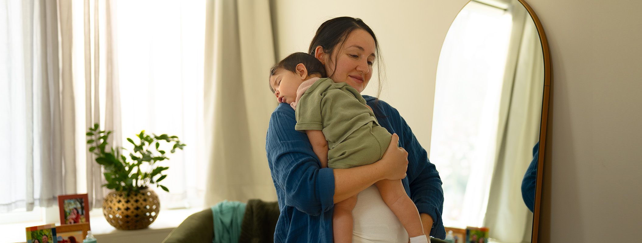 happy mom with sleeping baby on shoulder