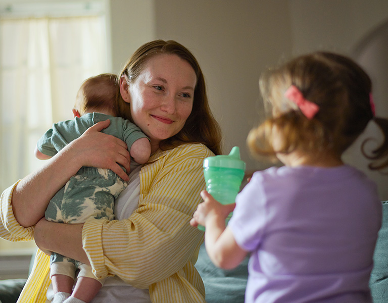 Woman in yellow striped shirt with her children